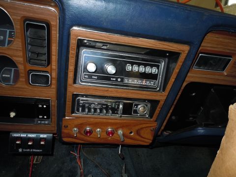 2001 Ford Crown Victoria - Interior view of a car's dashboard, a retro radio and various control switches.