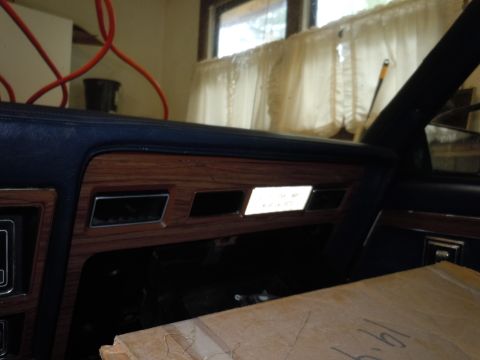 2001 Ford Crown Victoria - Close-up of a car's dashboard, wood-like trim and a illuminated display panel.