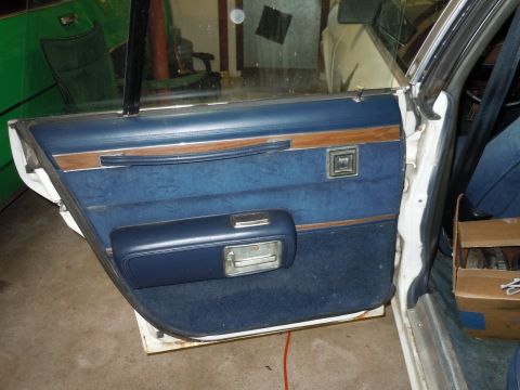2001 Ford Crown Victoria - Close-up of a car's interior door panel, showing blue fabric and wood accents.