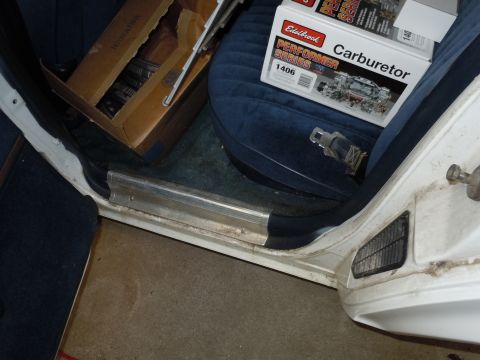 2001 Ford Crown Victoria - The interior of a car shows a box of parts and a new Edelbrock carburetor on the seat.