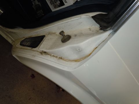 2001 Ford Crown Victoria - Close-up of a car's interior door jamb, showing signs of wear and rust.