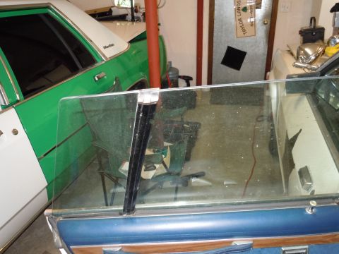 2001 Ford Crown Victoria - A close-up view of a car's interior door panel and window frame, with another vehicle partially visible in the background.