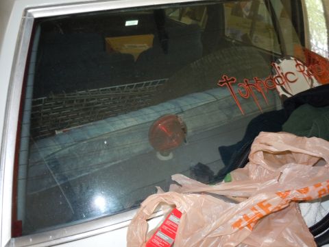 2001 Ford Crown Victoria - Car trunk interior filled with various items, including plastic bags and clothing.