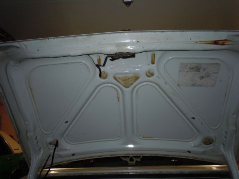 2001 Ford Crown Victoria - The interior of a car's trunk shows white paint, some rust, and the latch assembly.