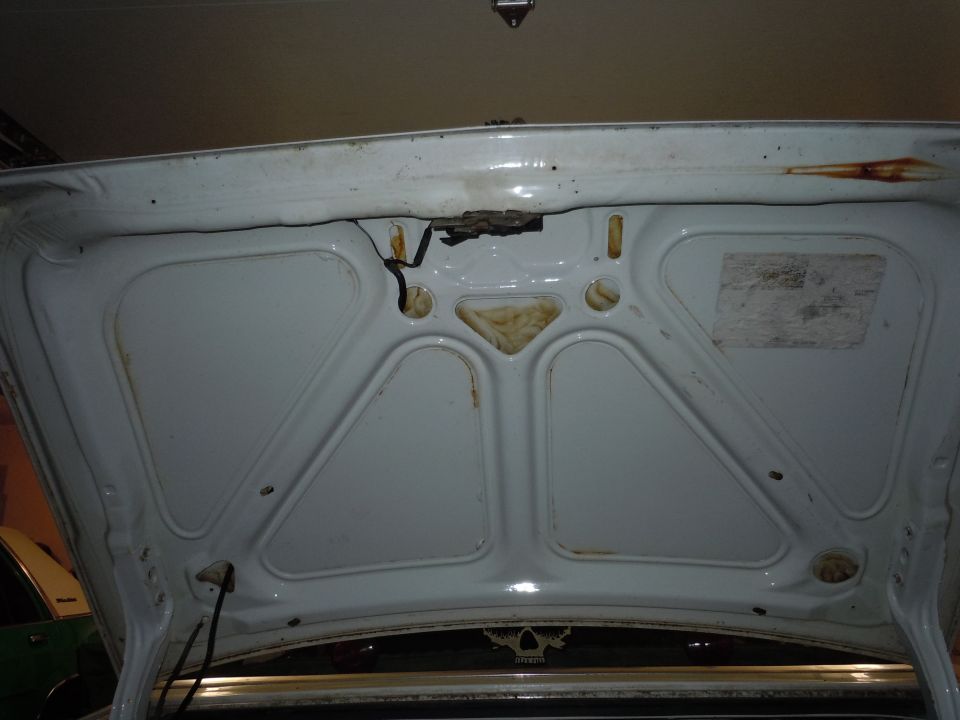 White trunk interior with rust spots and visible latch mechanism