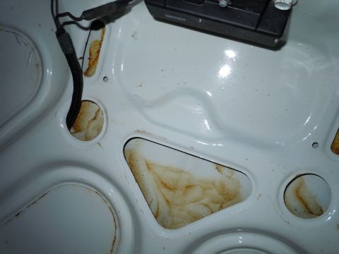2001 Ford Crown Victoria - The underside of a car hood shows some rust and a black wire loom, indicating potential wear or damage.