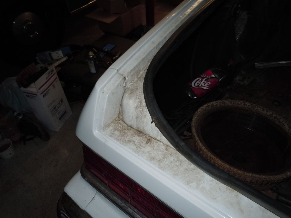 White 2001 Ford Crown Victoria trunk interior with a Diet Coke bottle and a basket