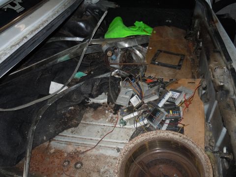 2001 Ford Crown Victoria - The interior of a vehicle is filled with various electronic components and debris, obscuring the original vehicle details.