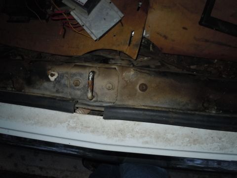 2001 Ford Crown Victoria - Close-up of a corroded car door latch assembly, showing wear and tear on the metal components.