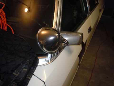 2001 Ford Crown Victoria - Close-up of a chrome side mirror on a white vehicle's door.
