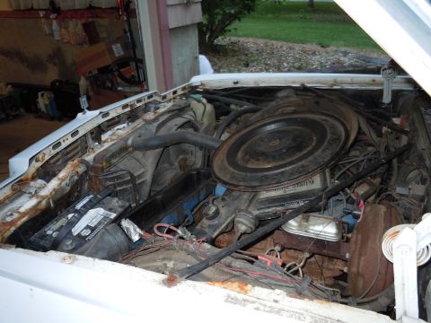 2001 Ford Crown Victoria - The engine bay of a vehicle, showing the battery, air cleaner, and various engine components.