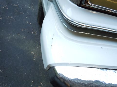 2001 Ford Crown Victoria - Close-up of a 2001 Ford Crown Victoria's front bumper showing chrome trim and a paint crack.