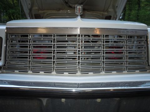 2001 Ford Crown Victoria - Front view of a white Dodge vehicle's grille, chrome accents and a hood ornament. The registry information may be incorrect.