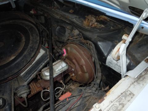 2001 Ford Crown Victoria - The engine bay of a vehicle shows various components including the brake booster and master cylinder.