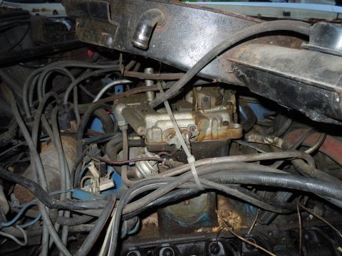 2001 Ford Crown Victoria - Close-up view of a cluttered engine bay, focusing on the carburetor and surrounding components.