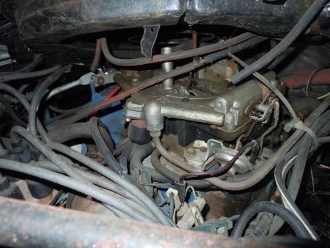 2001 Ford Crown Victoria - Close-up view of a vehicle's engine bay, focusing on the carburetor and a complex network of hoses and wires.