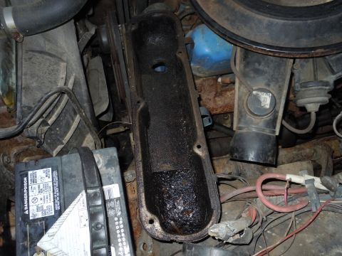 2001 Ford Crown Victoria - Close-up of an engine valve cover showing significant oil accumulation.