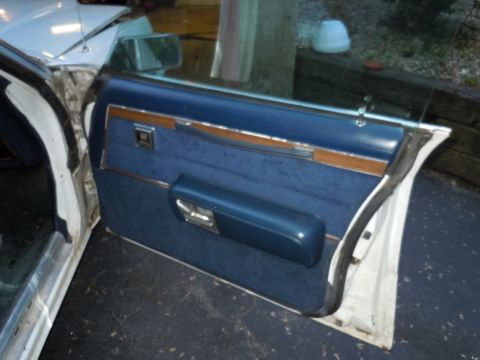 2001 Ford Crown Victoria - Interior view of a car door panel, showing blue fabric upholstery and wood accents.
