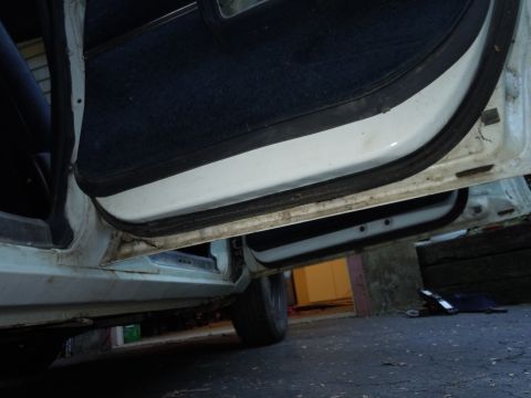 2001 Ford Crown Victoria - Close-up view of the interior door frame and carpet, showing wear and tear.