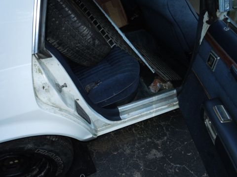 2001 Ford Crown Victoria - Spare tire and seat visible inside a car's interior.
