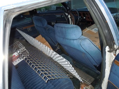 2001 Ford Crown Victoria - The interior of a car is filled with various items, including metal grates and boxes, obscuring the view of the vehicle's model year.
