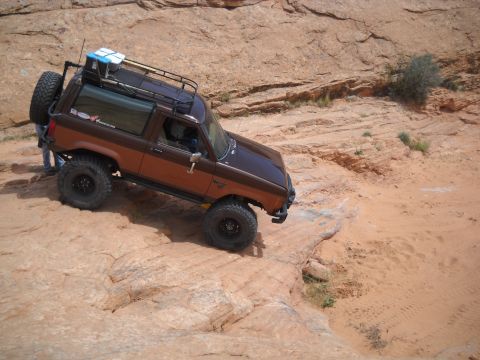 1986 Ford Bronco II - A two-tone brown Ford Bronco II navigates a challenging rocky trail.