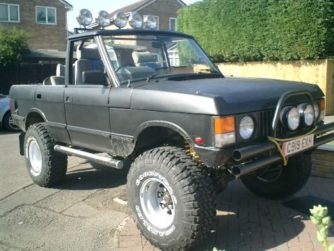 1990 Chevrolet Suburban - This modified Range Rover features off-road tires, a light bar, and a convertible top, deviating from the 1990 Chevrolet Suburban claim.