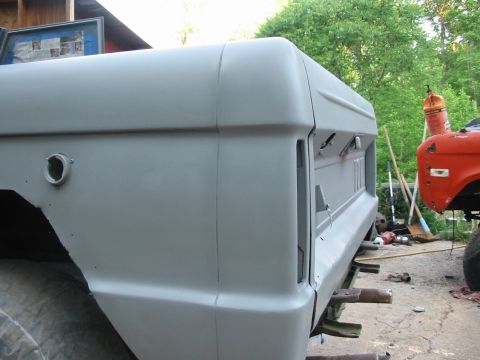 1969 Ford Bronco - A gray 1966 Ford Bronco tailgate and rear quarter panel are shown in primer, with another vehicle visible in the background.