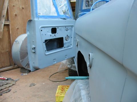 1969 Ford Bronco - The side of a 1969 Ford Bronco is shown with the driver's door open, revealing the interior and door panel, as it undergoes preparation for…