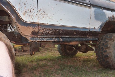 1978 Ford Bronco - This image shows the lower body and suspension of a mud-covered off-road vehicle, highlighting its rock skids.