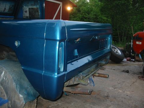 1969 Ford Bronco - Rear view of a blue Ford Bronco undergoing restoration, with another vehicle in the background.