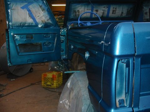 1969 Ford Bronco - The vehicle is undergoing a paint job, with protective coverings and newspaper used to mask off areas.