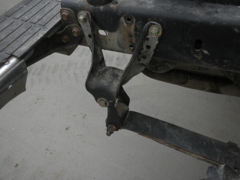 1989 Ford Bronco - Close-up of a vehicle's suspension components, specifically a leaf spring and shackle flip bracket.