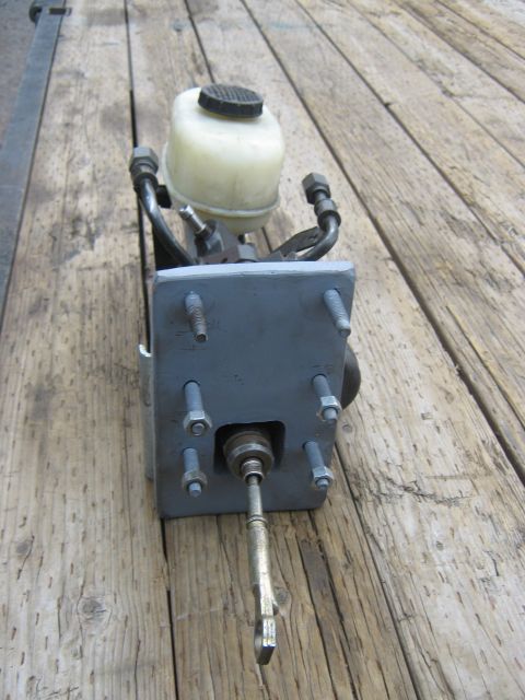 1978 Ford Bronco - This is a brake master cylinder assembly, likely for a vehicle, shown on a wooden surface.
