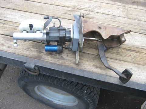 1978 Ford Bronco - Brake booster and pedal assembly shown on a wooden surface, likely for sale or repair.
