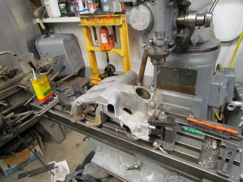 1995 Ford Probe - An engine intake manifold is being worked on with a milling machine in a workshop setting.