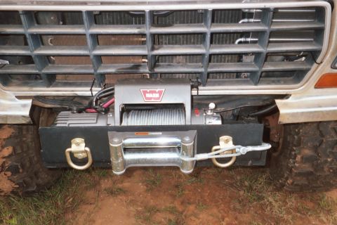 1978 Ford Bronco - A WARN winch and heavy-duty tow hooks are mounted to the front bumper of an off-road vehicle.