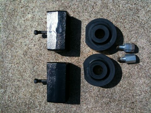 1996 Ford Bronco - These are lift kit components, likely for a truck or SUV, laid out on a concrete surface.