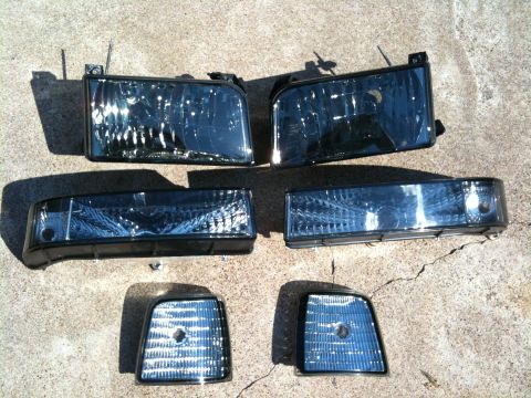 1996 Ford Bronco - Aftermarket headlights and corner lights are displayed on a concrete surface.