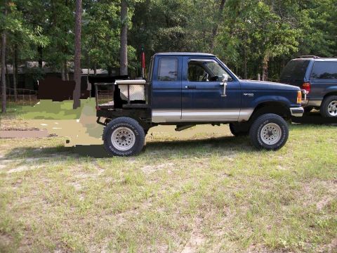 1994 Ford Explorer - This blue Ford Ranger pickup truck features a flatbed conversion and a toolbox mounted behind the cab.
