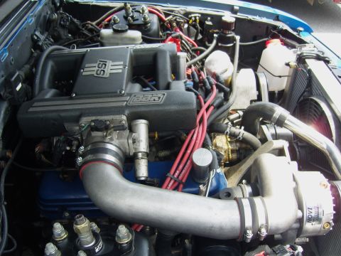 2007 Ford Mustang - Close-up view of a modified engine bay, highlighting the supercharger and intake system.
