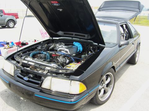 2007 Ford Mustang - A black Ford Mustang is parked with its hood and trunk open, revealing the engine bay and interior details.