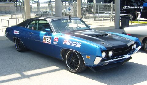 2007 Ford Mustang - A blue 1970 Ford Torino coupe with racing decals is parked at an event.
