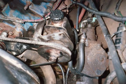 1978 Ford Bronco - Close-up view of a power steering pump and associated components within an engine compartment.