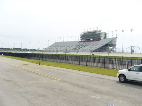 2007 Ford Mustang - A view of the grandstands and track at a speedway, with a white SUV in the foreground.