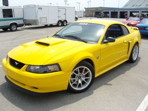 2007 Ford Mustang - Yellow 2007 Ford Mustang with a hood scoop and silver wheels.