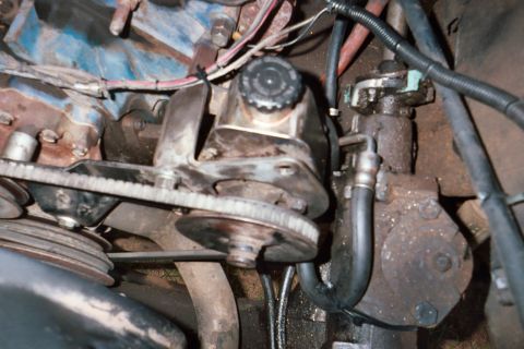 1978 Ford Bronco - This image shows a close-up view of the power steering pump and associated pulleys and belts within a vehicle's engine bay.