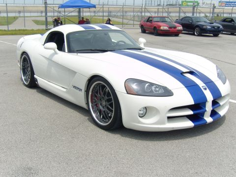2007 Ford Mustang - White Dodge Viper with blue stripes parked on asphalt, with other vehicles in the background.