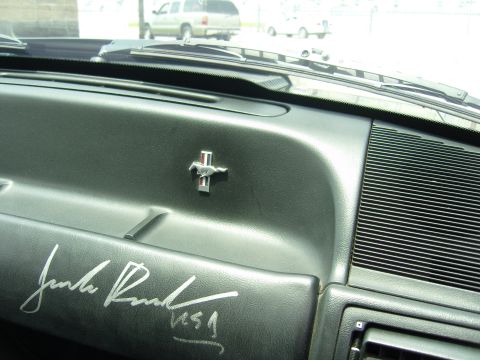 2007 Ford Mustang - Interior view of a 1994 Ford Mustang dashboard, the iconic running horse emblem and a signature.