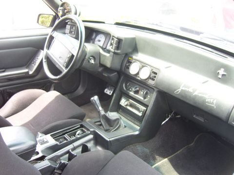 2007 Ford Mustang - The interior of a car shows a manual transmission, aftermarket gauges, and a signature on the dashboard.